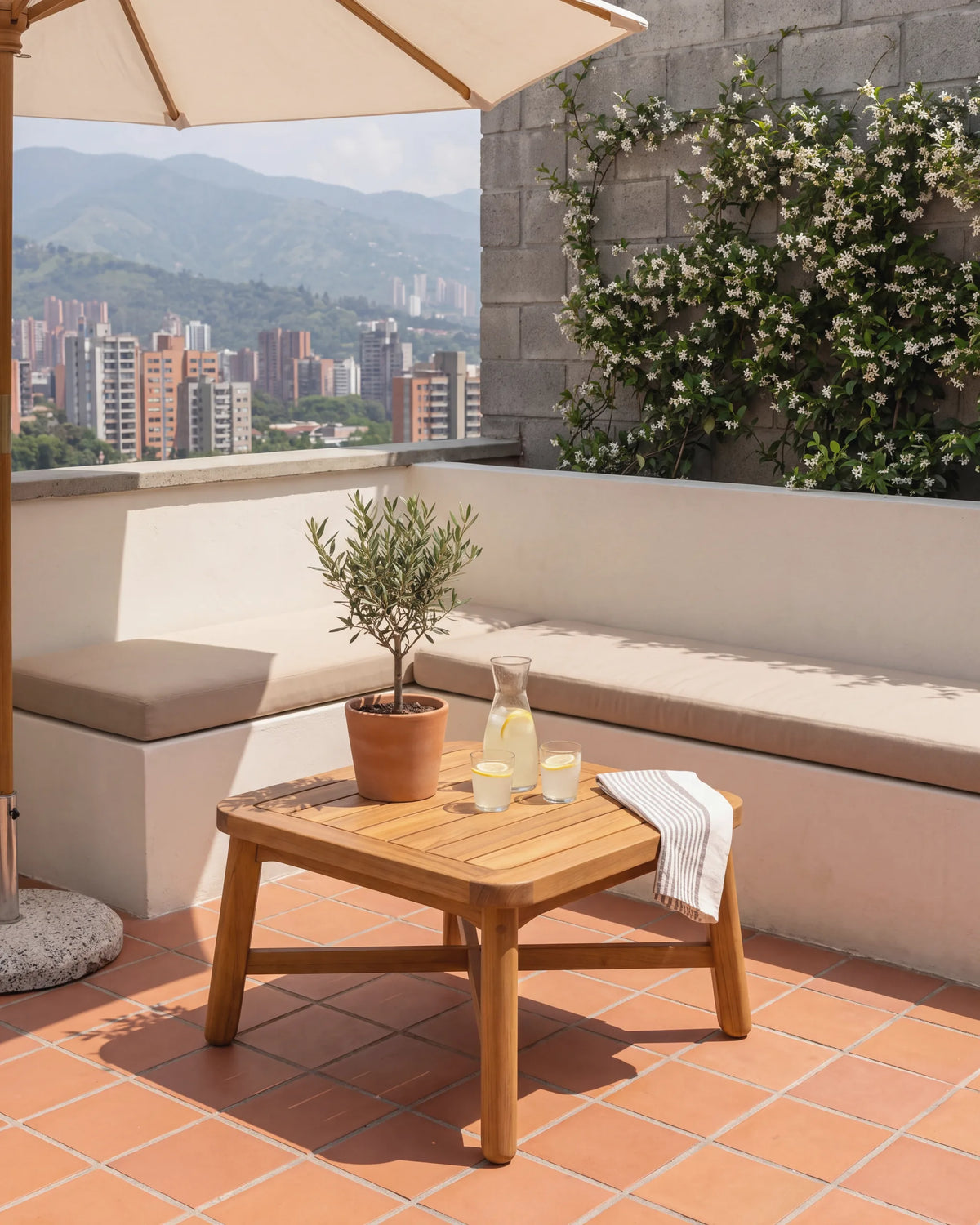 Mesa auxiliar de teca en la terraza de un penthouse en Ciudad del Río con vista a Medellín