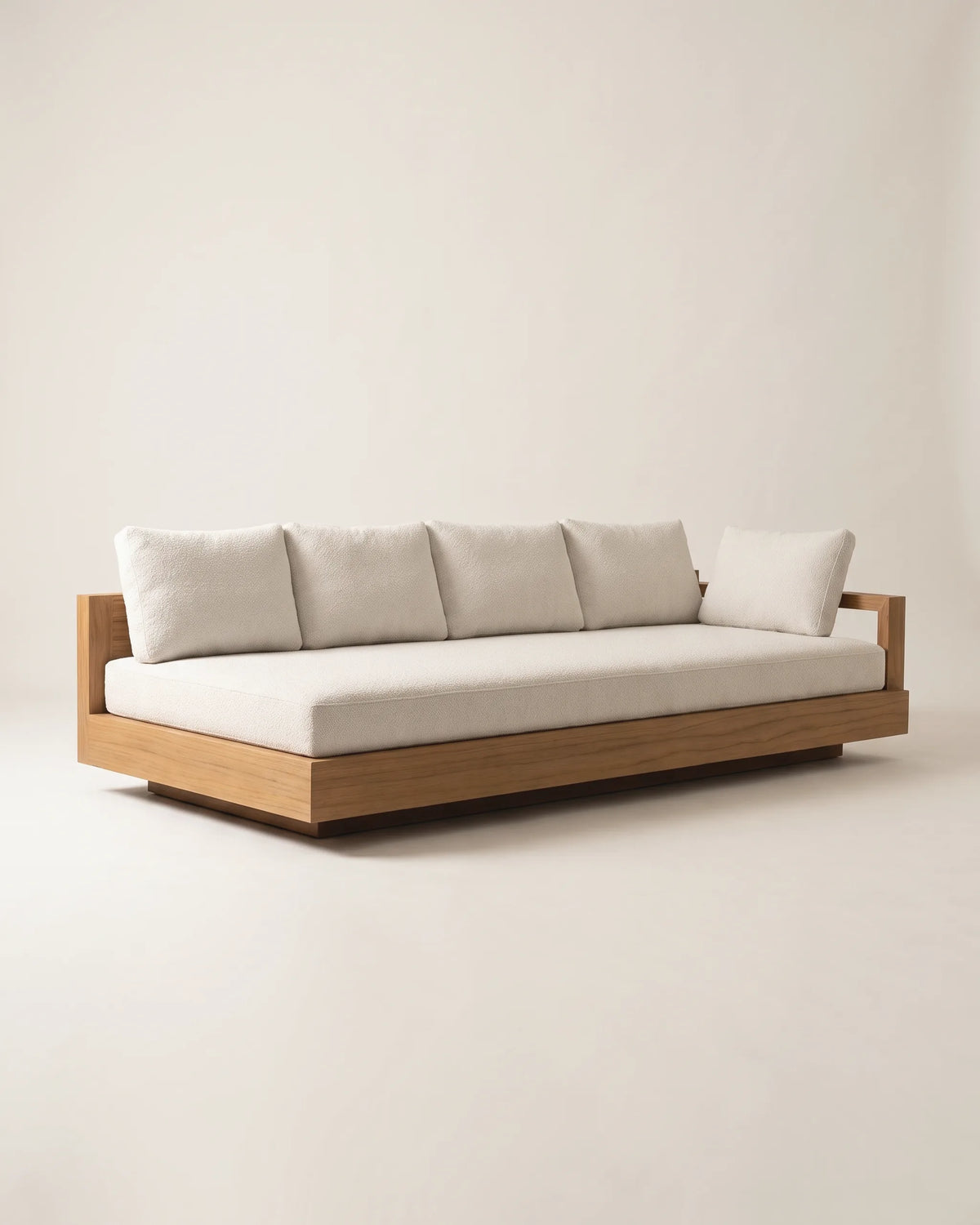 Vista en tres cuartos del sofá cama de madera con brazo abierto y cojines crema sobre fondo claro