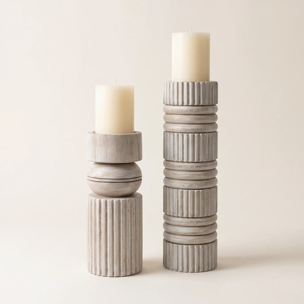 Candelabros de madera en blanco lavado de 40 y 28,5 cm con velas de pilar crema sobre fondo claro