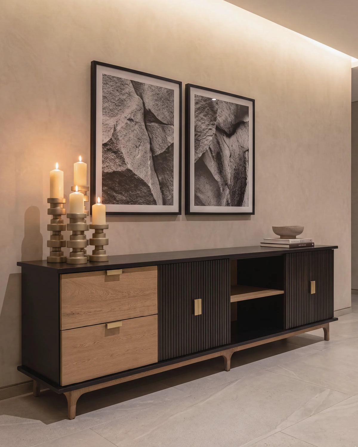 Consola de roble y negro con candelabros dorados en el recibidor de un apartamento en El Poblado