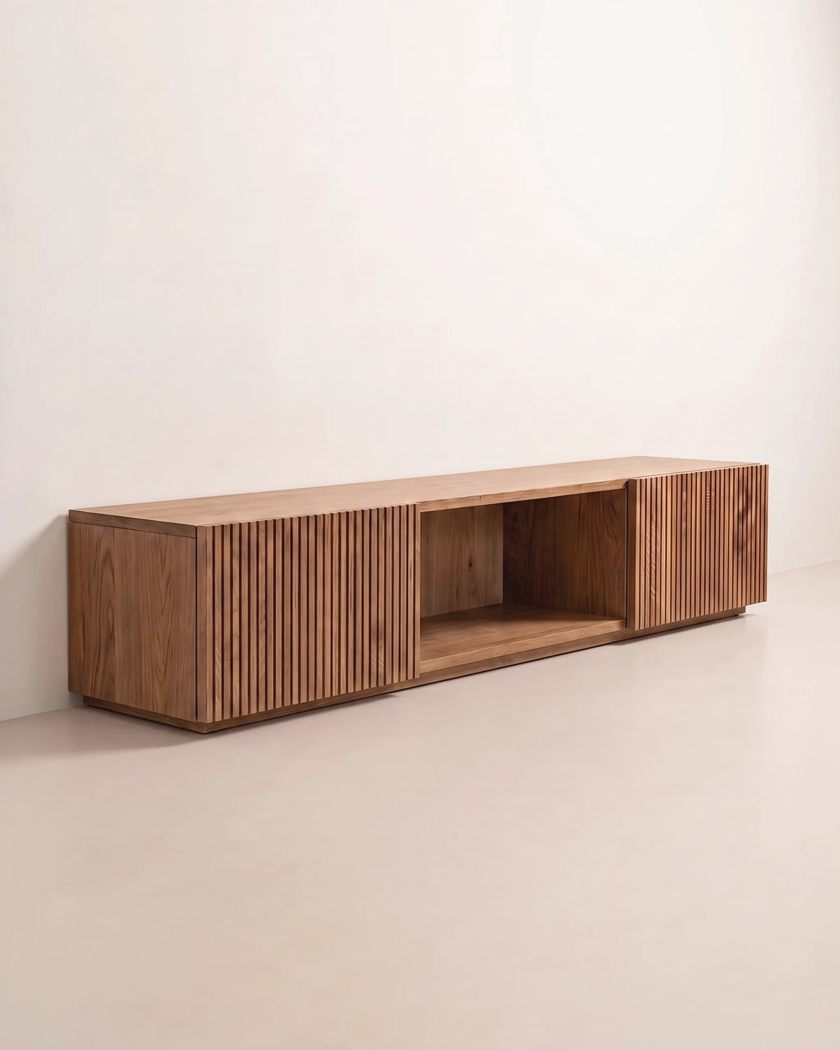 Vista en tres cuartos del mueble para TV de madera con puertas acanaladas sobre fondo claro