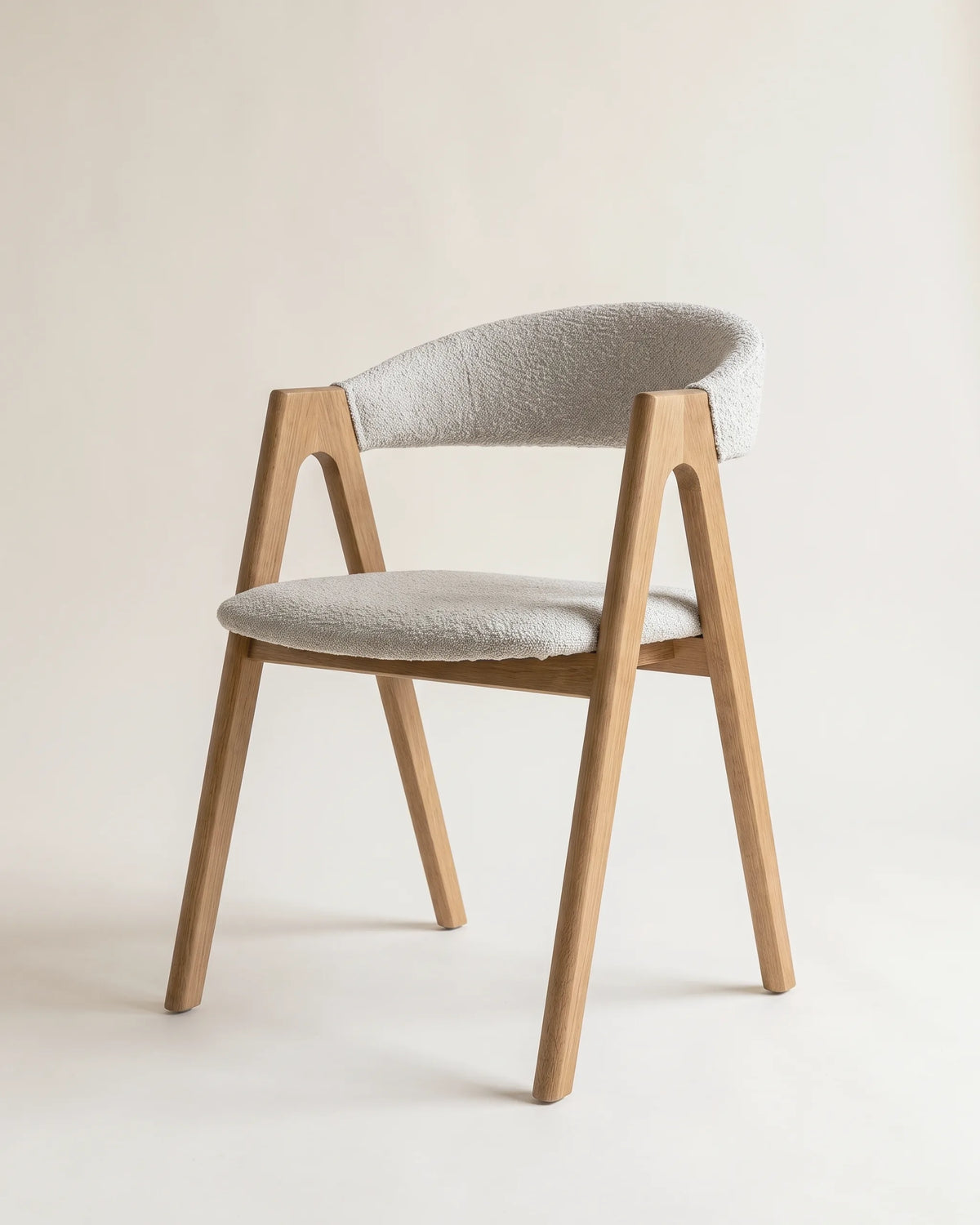 Silla de comedor de roble con costados en A y respaldo curvo tapizado en bouclé gris claro